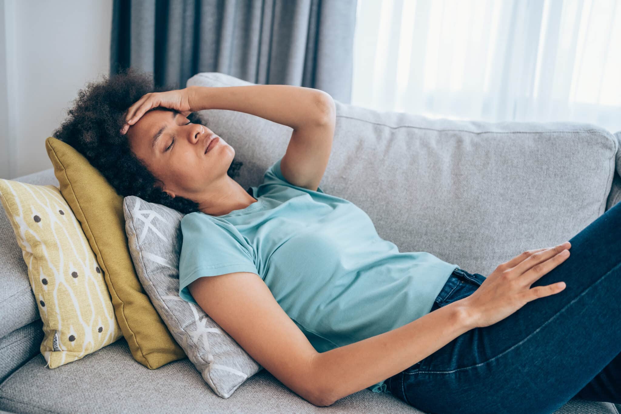Woman lying on couch experiencing stressful times