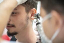 Man at the ENT doctor recieving an ear exam