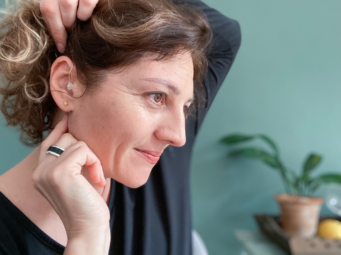 Woman admiring her new hearing aid.