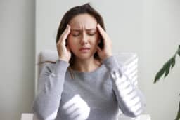 Woman with headache holds head