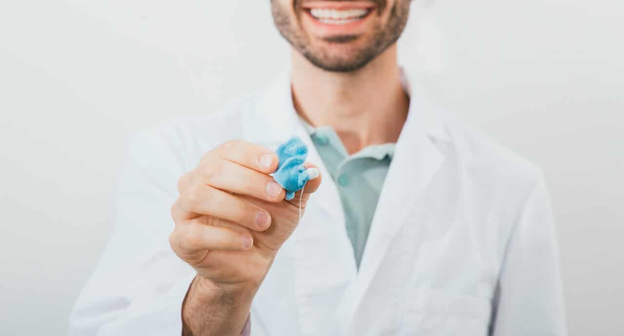 Audiologist holding up a custom earplug.