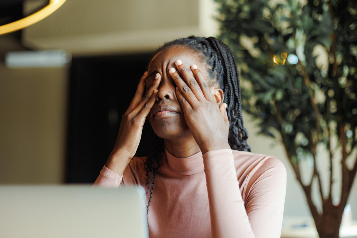 Tired woman rubbing her eyes.