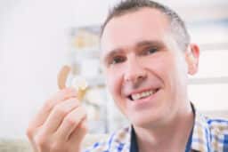 Man holding up his new hearing aids